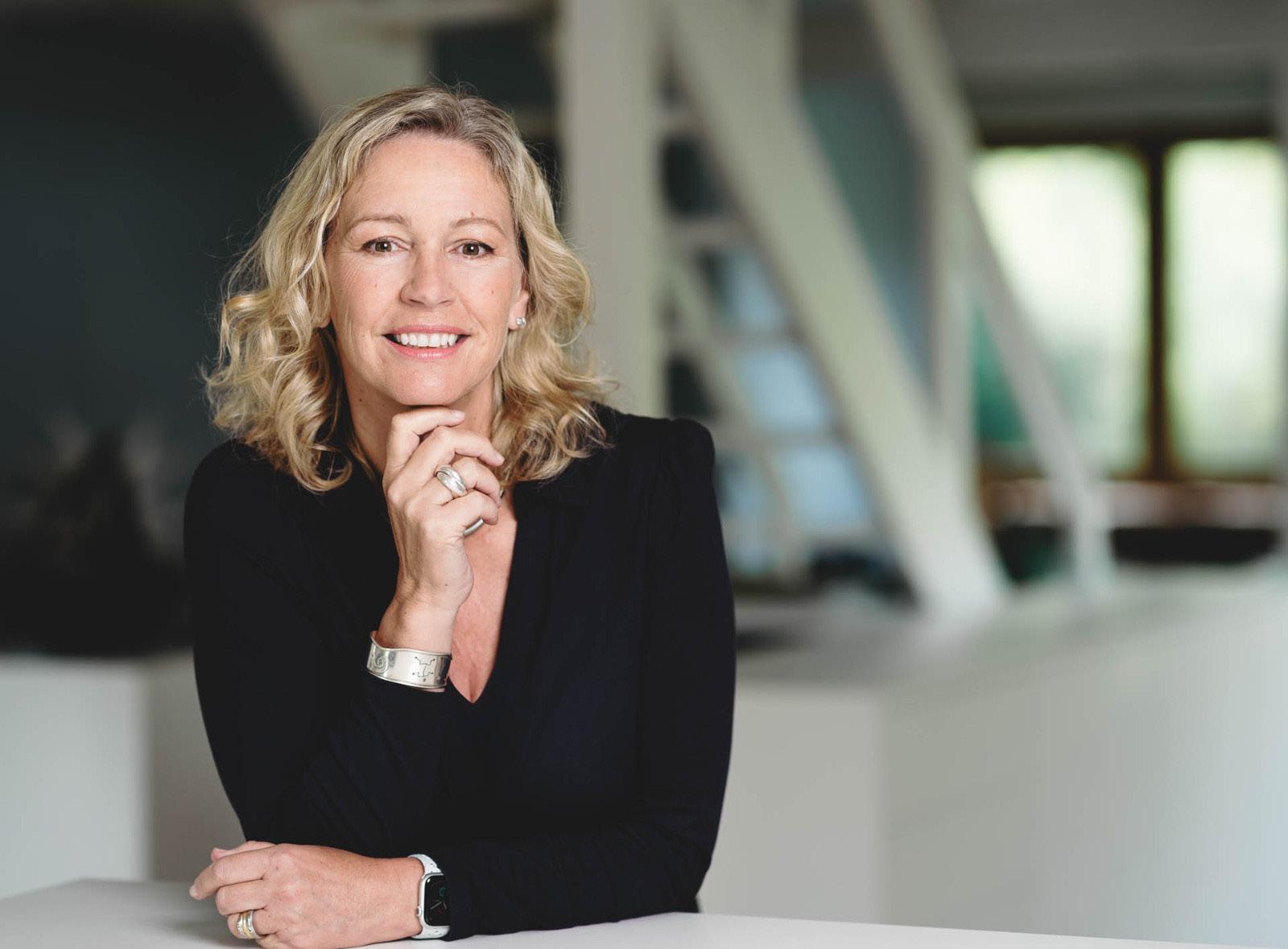 Claudia Brett, menopause expert and coach, smiling at a table.